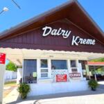 Dairy Kreme storefront with a brown gabled roof, white walls, and a 'CLOSED' sign in the window on a sunny day.