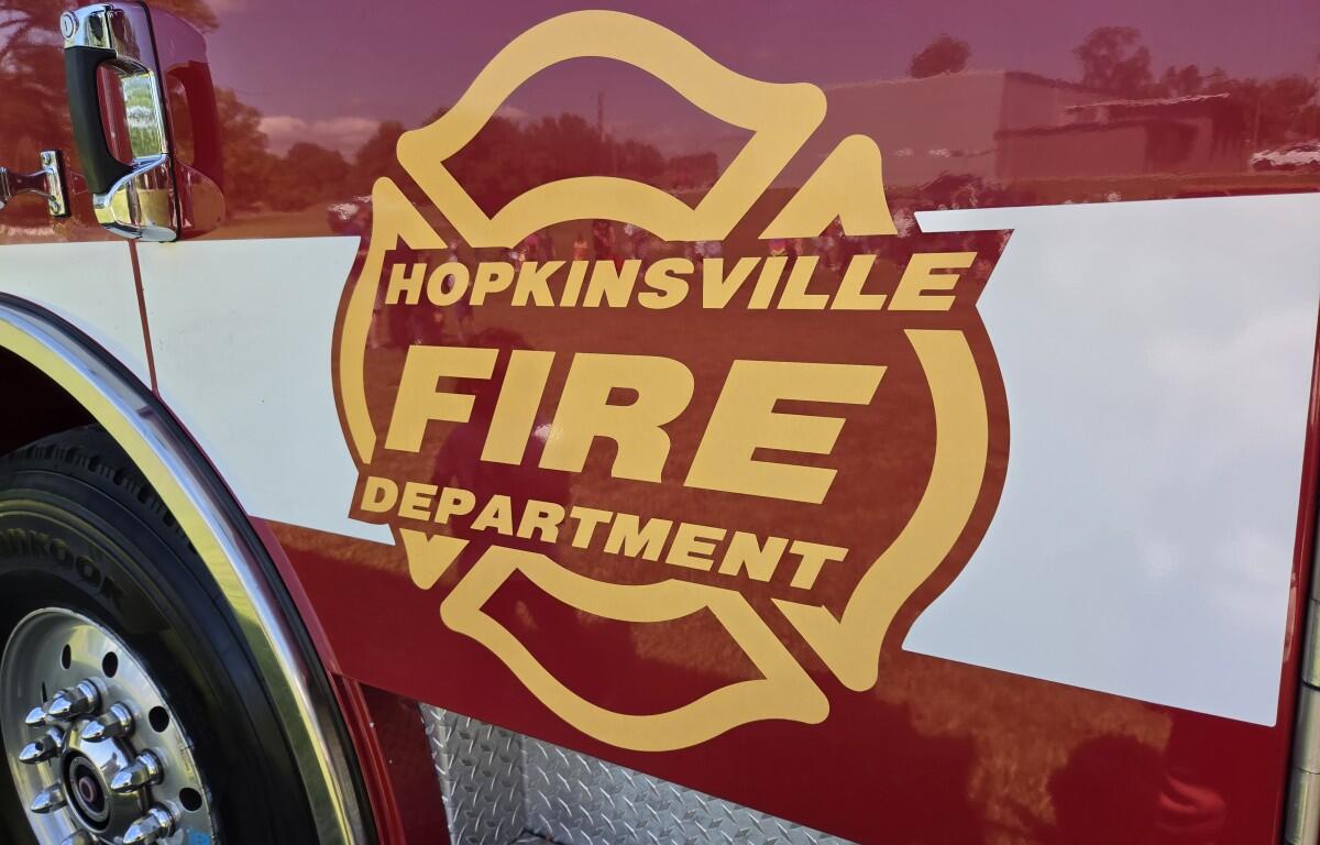 Front side of a fire engine with a large Hopkinsville Fire Department emblem in gold and red, lettering visible.