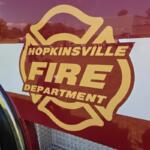 Front side of a fire engine with a large Hopkinsville Fire Department emblem in gold and red, lettering visible.
