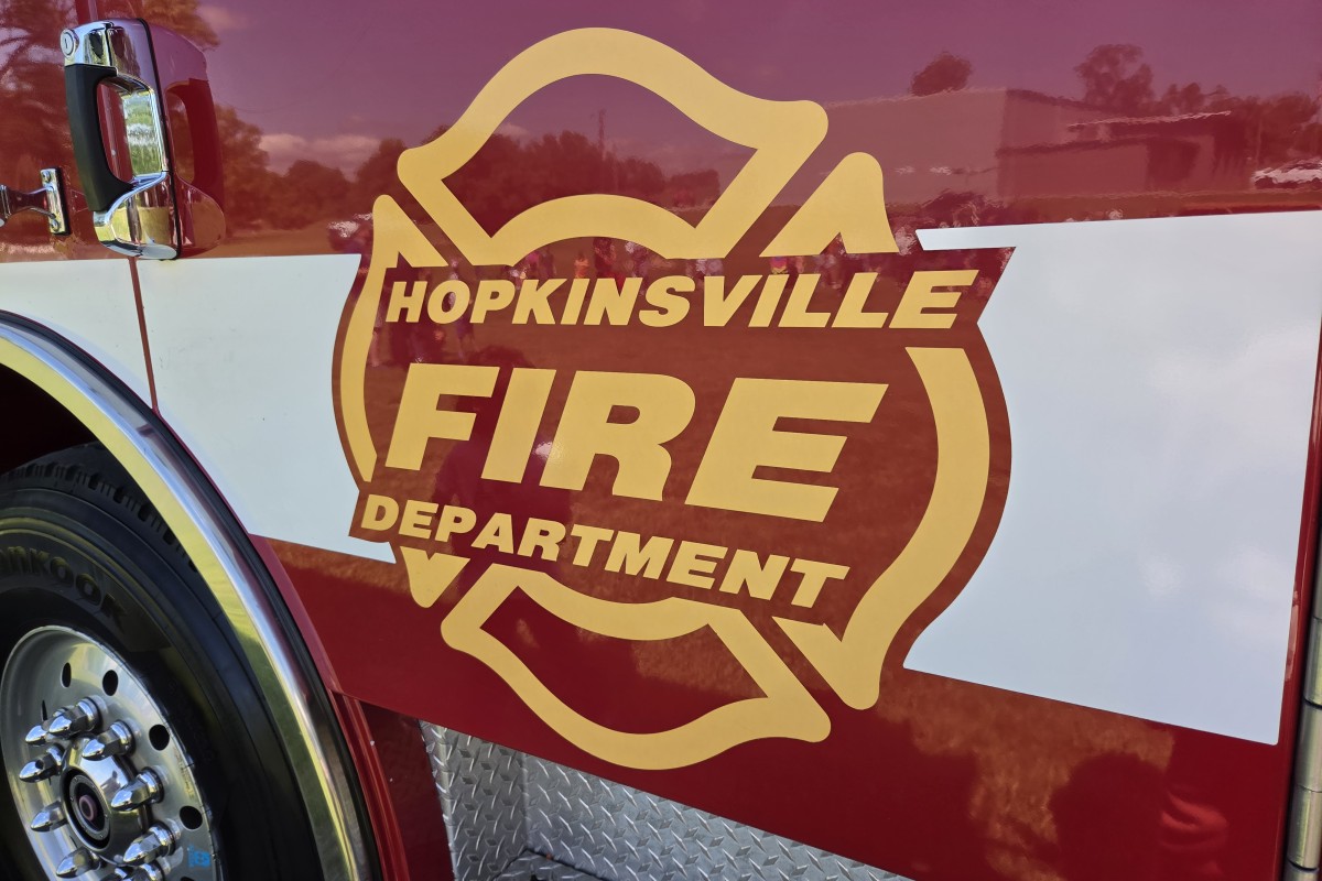 Front side of a fire engine with a large Hopkinsville Fire Department emblem in gold and red, lettering visible.