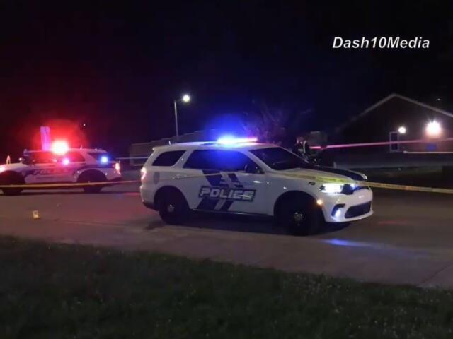 Police cars with flashing blue and red lights on a street at night, yellow tape cordoning off the area.